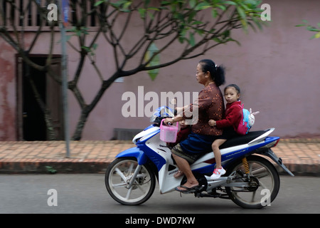 Mère et fille équitation une moto dans une rue de Luang Prabang, Laos. Banque D'Images