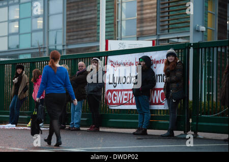 Pays de Galles Aberystwyth Uk, le jeudi 6 mars 2014 Des membres de "Cymdeithas yr Iaith' (La Société de la langue galloise) Groupe de protestation se sont enchaînés à l'entrée principale de la portes des bureaux régionaux du gouvernement gallois à Aberystwyth dans les premières heures du jeudi 6 mars 2014. L'action est une partie d'une série de militants linguistiques organisera au cours du printemps en réponse à la crise dans le nombre de locuteurs du gallois au Pays de Galles a révélé par les résultats du recensement publié il y a un an, et ce qu'ils disent est le manque de leadership et de la politique officielle par le gouvernement gallois. Credit : Keith morris/Alamy vivre Banque D'Images