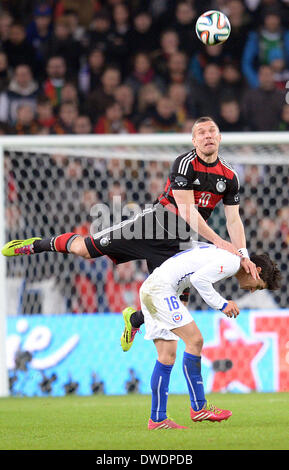 Stuttgart, Allemagne. Le 05 Mar, 2014. L'Allemagne Lukas Podolski (T) convoite la la balle avec le Chili's Felipe Gutierrez (B) au cours de la match amical entre l'Allemagne et le Chili à Mercedes-Benz-Arena de Stuttgart, Allemagne, 05 mars 2014. Photo : Bernd Weissbrod/dpa/Alamy Live News Banque D'Images