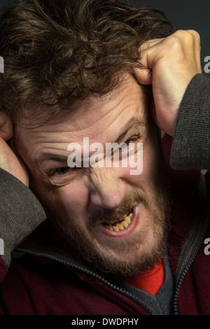 Un homme en colère avec un mauvais caractère déchirant ses cheveux. Banque D'Images