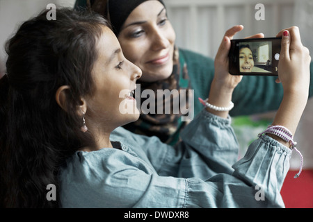 Mère et fille taking self portrait dans la chambre Banque D'Images