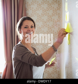 Portrait of businesswoman coller note notes sur tableau blanc Banque D'Images