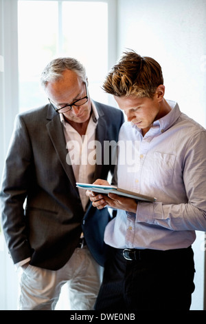 Hommes d'using digital tablet in office Banque D'Images