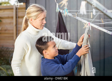 Mère et fils faire la lessive à la cour Banque D'Images