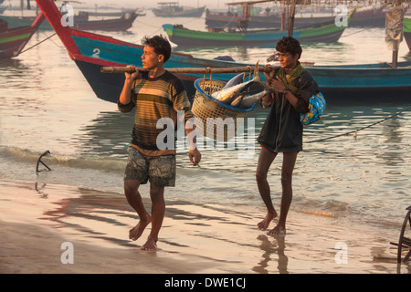 Les hommes portant le birman nuits à terre des prises à l'aube, près du village de pêcheurs à la plage de Ngapali - Myanmar (Birmanie) Banque D'Images