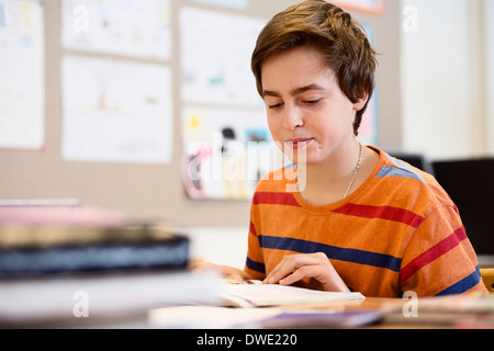 High school boy studying at desk in classroom Banque D'Images