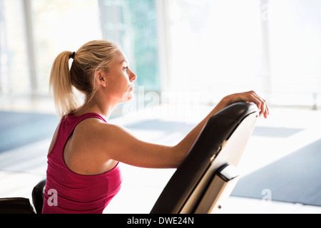 Young woman sitting on chair at gym Banque D'Images