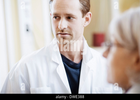 Mid adult male doctor with female colleague in hospital Banque D'Images