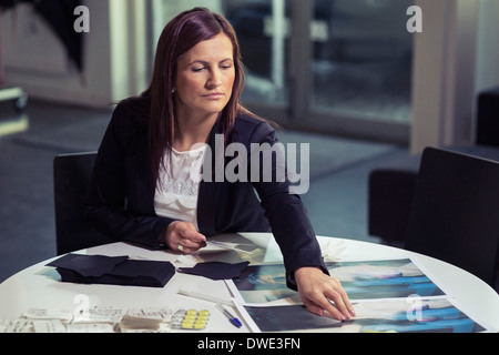 Businesswoman working on photographies in office Banque D'Images