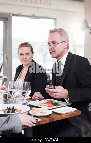 Les gens d'affaires ayant la nourriture au restaurant Banque D'Images