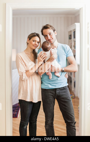 Portrait of mid adult coupé avec bébé fille à l'entrée Banque D'Images