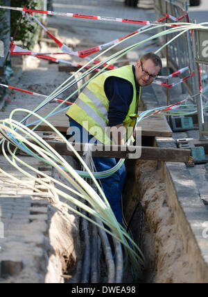 BEnsheim, Allemagne. Le 05 Mar, 2014. Un travailleur fixe Speed-Pipe tubules souterrain pour les réseaux fibre optique et les câbles d'électricité sur un site de construction à BEnsheim, Allemagne, 05 mars 2014. Les câbles à fibres optiques sont tirés dans les tubes avec la pression de l'air. Photo : Arne Dedert/dpa/Alamy Live News Banque D'Images