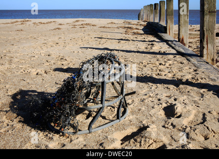 Un vieux lobster pot lavé-up sur la plage à Horsey, Norfolk, Angleterre, Royaume-Uni. Banque D'Images