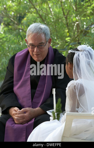 GUATEMALA prêtre missionnaire catholique américain dans le Petén jeune fille donnant sa première communion. Banque D'Images