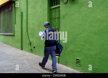 La Mailman trie le courrier en marchant sur la rue San Francisco Banque D'Images