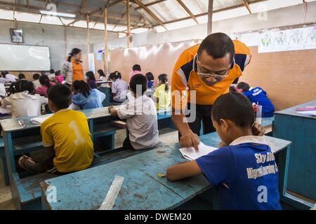 Mae Sot, Tak, en Thaïlande. 6Th Mar, 2014. L'enseignant travaille avec les élèves de l'école bleu ciel. Il y a environ 140 élèves de l'école bleu ciel, au nord de Mae Sot. L'école est à côté de la décharge principale de Mae Sot et sert les enfants des personnes qui travaillent dans la décharge. L'école s'appuie sur les subventions et les dons d'Organisations Non Gouvernementales (ONG). Les réformes dans le Myanmar ont alllowed les ONG pour l'exploitation de l'homme au Myanmar, à la suite de nombreuses ONG sont le déplacement des ressources aux opérations au Myanmar, laissant les migrants et les réfugiés birmans en Thaïlande vulnérables. Le ciel bleu l'école n'est pas ab Banque D'Images