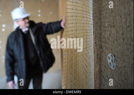 Verden, Allemagne. Feb 27, 2014. Le gestionnaire de l'Amérique du Centre allemand pour la construction durable, l'entreprise Christian Silberhorn, examine les murs en pisé dans un projet de construction écologique pour un immeuble de bureaux dans la région de Verden, Allemagne, 27 février 2014. Photo : Ingo Wagner/dpa/Alamy Live News Banque D'Images