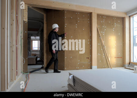 Verden, Allemagne. Feb 27, 2014. Le gestionnaire de l'Amérique du Centre allemand pour la construction durable, l'entreprise Christian Silberhorn, examine les murs en pisé dans un projet de construction écologique pour un immeuble de bureaux dans la région de Verden, Allemagne, 27 février 2014. Photo : Ingo Wagner/dpa/Alamy Live News Banque D'Images