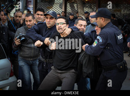 Alger, Algérie. 6Th Mar, 2014. La police à l'arrestation d'un manifestant au cours d'une manifestation contre le président algérien Abdelaziz Bouteflika a décidé de se présenter pour un quatrième mandat, à Alger, le 6 mars, 2014 Bouteflika, qui a aidé à mettre fin à l'Algérie des années 1990, la guerre civile dévastatrice, mais dont la récente règle a été tourmentée par les scandales de corruption, a déclaré à la télévision algérienne le 3 mars qu'il avait inscrit comme candidat à l'élection. Credit : Kamel Salah/NurPhoto ZUMAPRESS.com/Alamy/Live News Banque D'Images