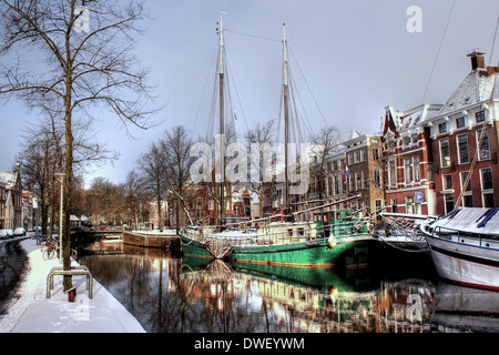 Canal à Hoge der A à Groningen (Pays-Bas) en hiver avec un vieux voilier amarré sur le quai Banque D'Images