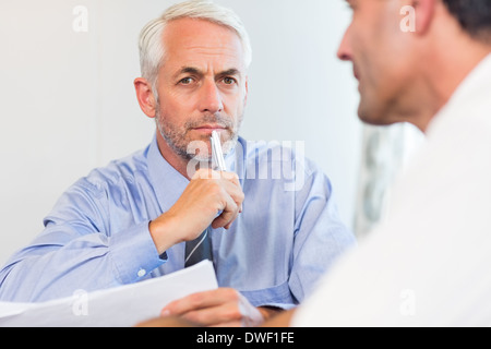 Hommes d'doing paperwork at office Banque D'Images