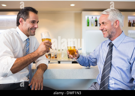 Des collègues ayant la bière au comptoir du bar Banque D'Images