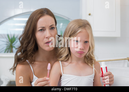 Mère et fille mécontent avec brosse à dents et dentifrice Banque D'Images