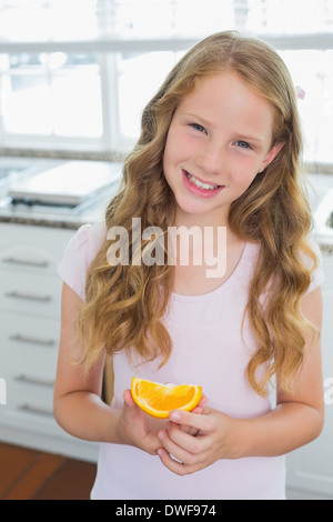 Souriante jeune fille avec un sweetlime tranche dans Cuisine Banque D'Images