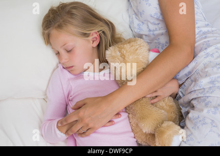 Mère et fille dormir paisiblement avec doudou dans le lit Banque D'Images