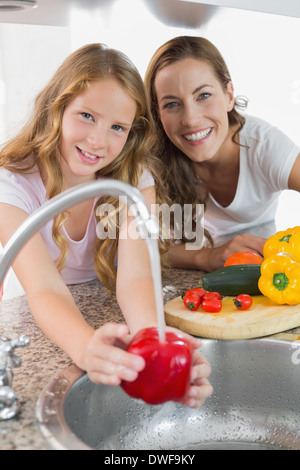 Portrait de jeune fille aider sa mère pour laver les légumes Banque D'Images