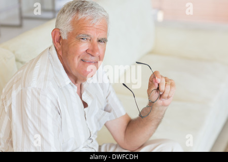 Happy senior man sitting on the couch holding glasses Banque D'Images