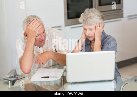 Couple inquiet à l'aide de l'ordinateur portable pour payer des factures Banque D'Images
