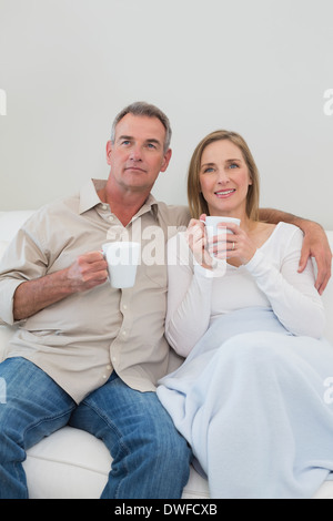 Couple aimant détendue avec des tasses à café dans la salle de séjour Banque D'Images