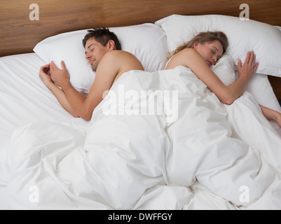 High angle view of couple sleeping in bed Banque D'Images