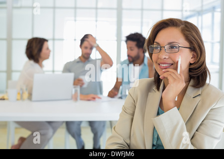 Smiling businesswoman with colleagues in meeting Banque D'Images