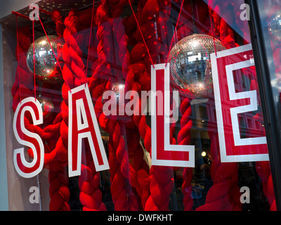 High Street shop au crépuscule avec la vente et l'affichage de la bannière dans la fenêtre Banque D'Images