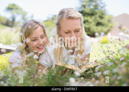 Mother and Daughter reading book in park Banque D'Images