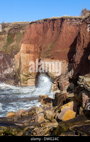 Des vagues de rochers côtières frappent le visage de la roche.Côte écossaise du nord-est du Royaume-Uni Banque D'Images