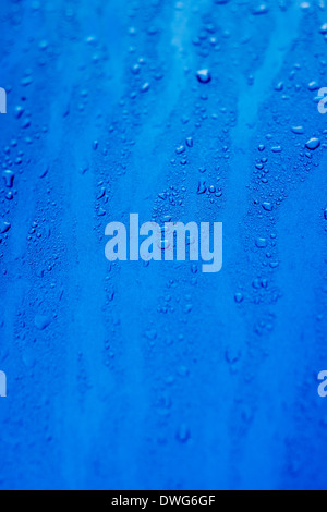 Les gouttelettes d'eau sur une surface bleue Banque D'Images