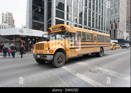 School bus sur West Street, dans le lower Manhattan, New York City, avec des mères et des enfants qui traversent la rue en face de lui. Banque D'Images