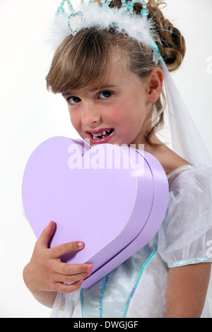 Petite Princesse holding entendre-shaped box Banque D'Images