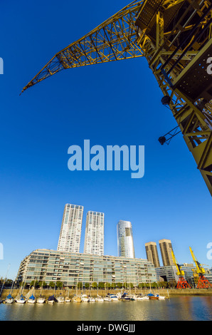 Front de mer de Puerto Madero à Buenos Aires, Argentine avec une grande grue jaune passant au-dessus Banque D'Images