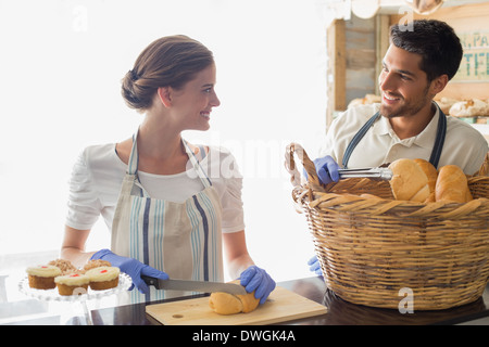 Smiling people avec des croissants au café restaurant counter Banque D'Images