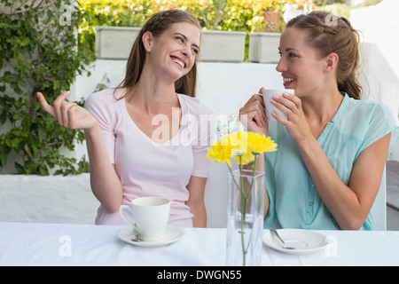 Happy female friends having coffee à la boutique Banque D'Images