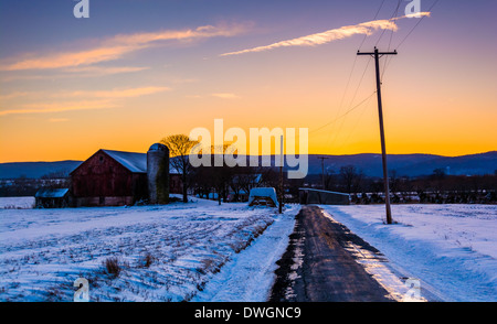 Grange et champs couverts de neige le long d'une route de campagne dans les régions rurales du comté de Frederick, Maryland. Banque D'Images