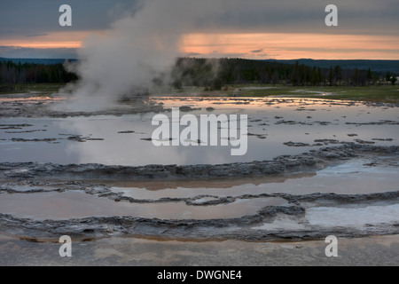 Grande Fontaine Geyser presse vapeur avant l'éruption au coucher du soleil à Lower Geyser Basin, Parc National de Yellowstone, Wyoming, USA. Banque D'Images