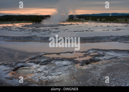 Grande Fontaine Geyser au coucher du soleil le long du lac Firehole dur à Lower Geyser Basin, Parc National de Yellowstone, Wyoming. Banque D'Images