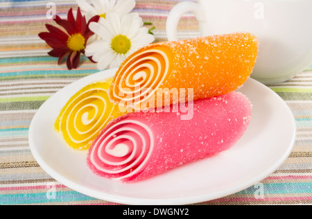 Bonbons colorés de paraffine sur une plaque avec chrysanthème fleur gros plan, d'arrière-plan Banque D'Images