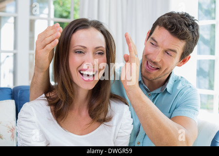 Jeune homme femme surprenant dans le salon Banque D'Images