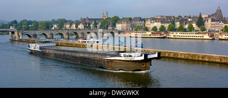 Le transport commercial Maastricht sur la rivière Meuse (rivière Maas) barge à moteur voyage le long du canal dédié en passant par le paysage urbain et les amarres de bateaux d'excursion Banque D'Images